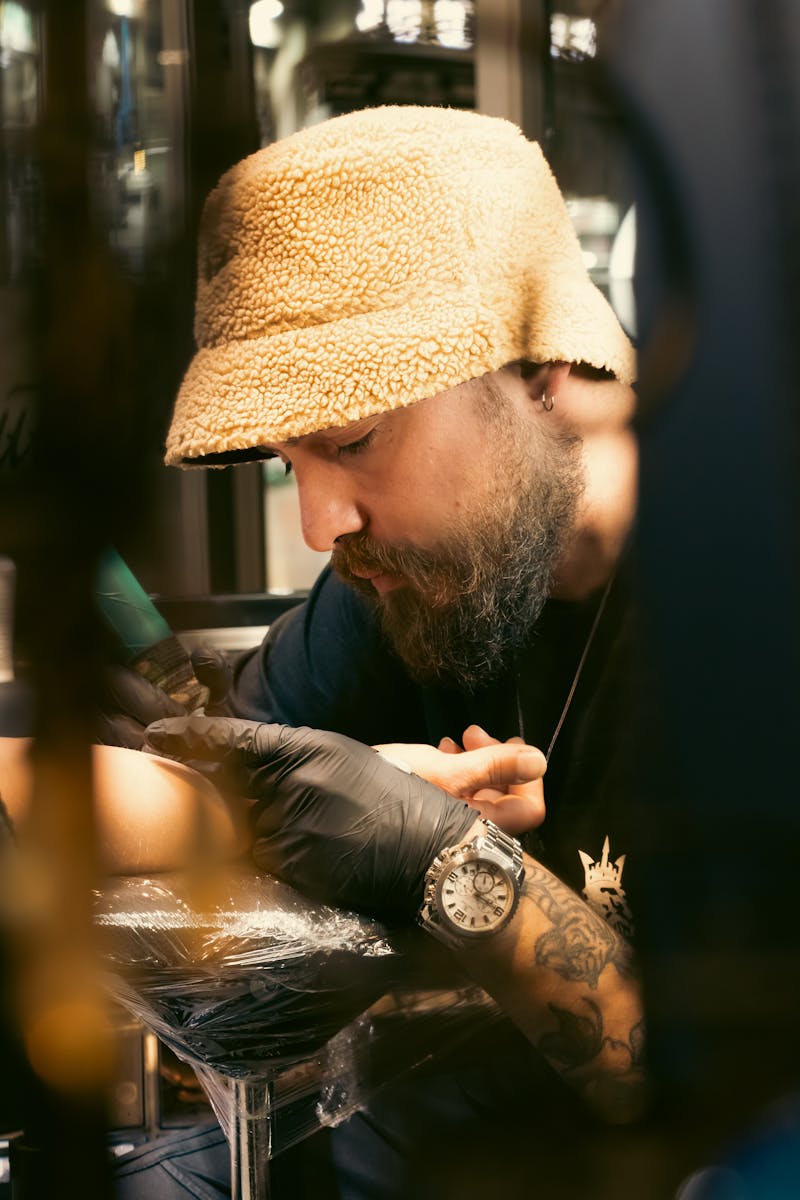 A man with a beard is getting his tattoo done